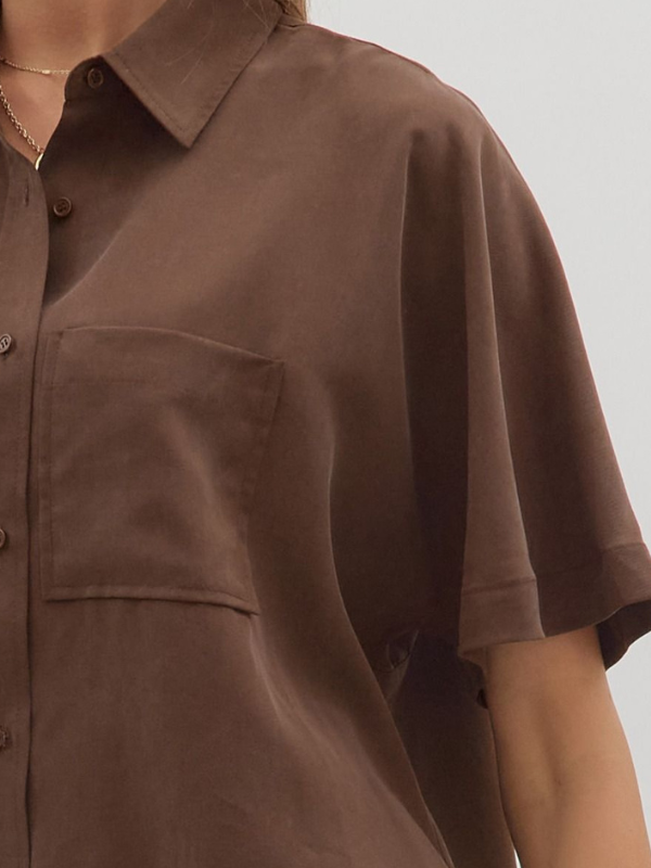 Brown short-sleeve shirt worn by a person on a plain background