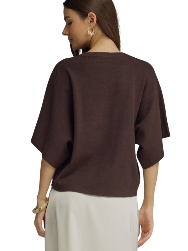 A woman shown from the back wearing a dark brown short-sleeve knit top and light beige pants against a plain white background.