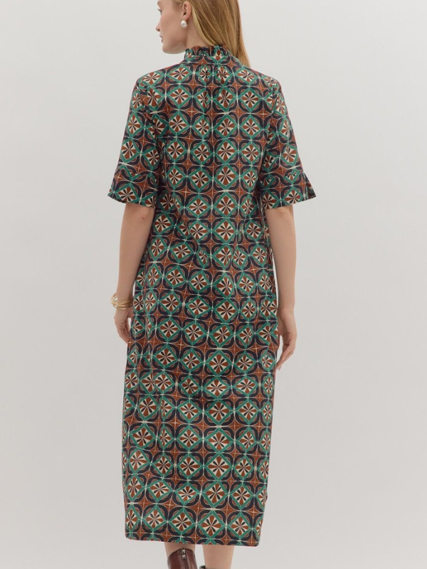 Woman wearing a patterned dress on a plain background