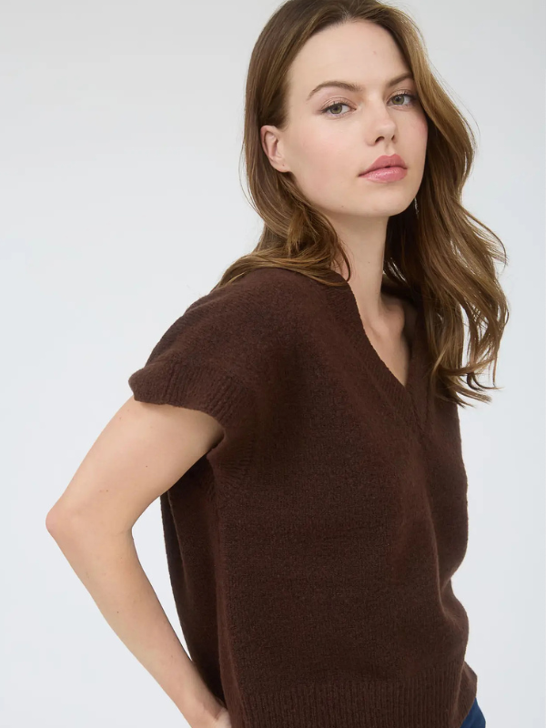 Woman wearing a brown sweater against a white background