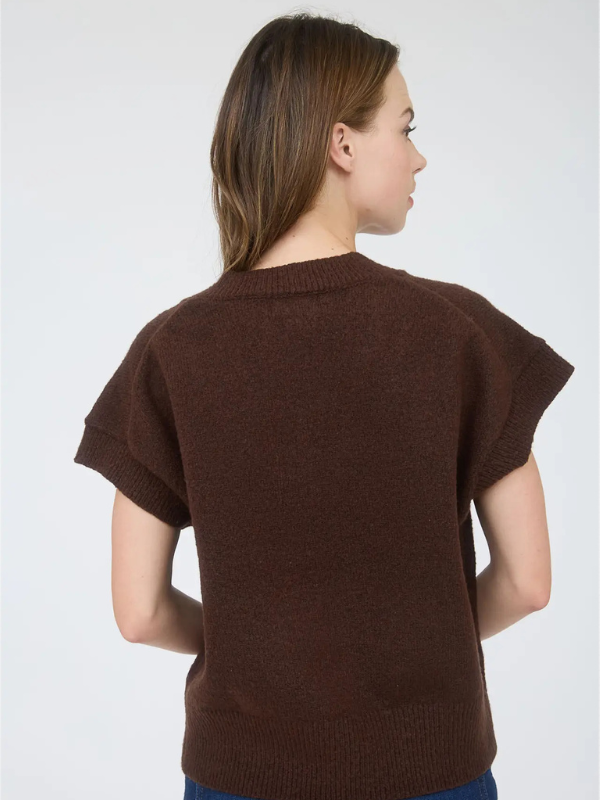 Woman wearing a brown knitted sweater against a white background