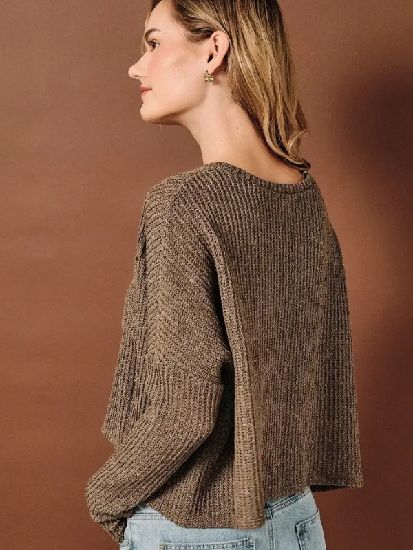 woman wearing a brown knit sweater and jeans