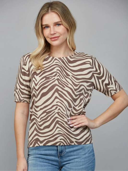 Woman wearing a zebra print shirt against a gray background