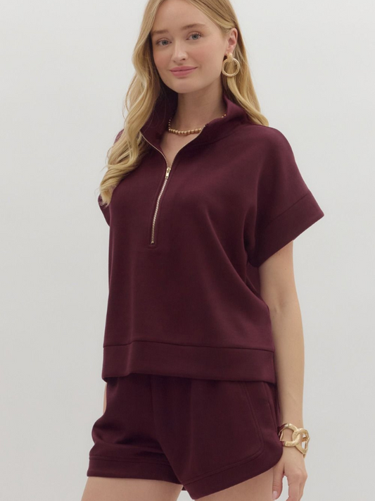 Woman wearing a burgundy outfit with a white background