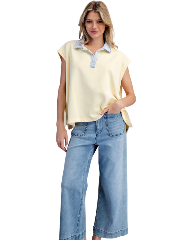 Woman wearing a yellow top and blue jeans on a white background