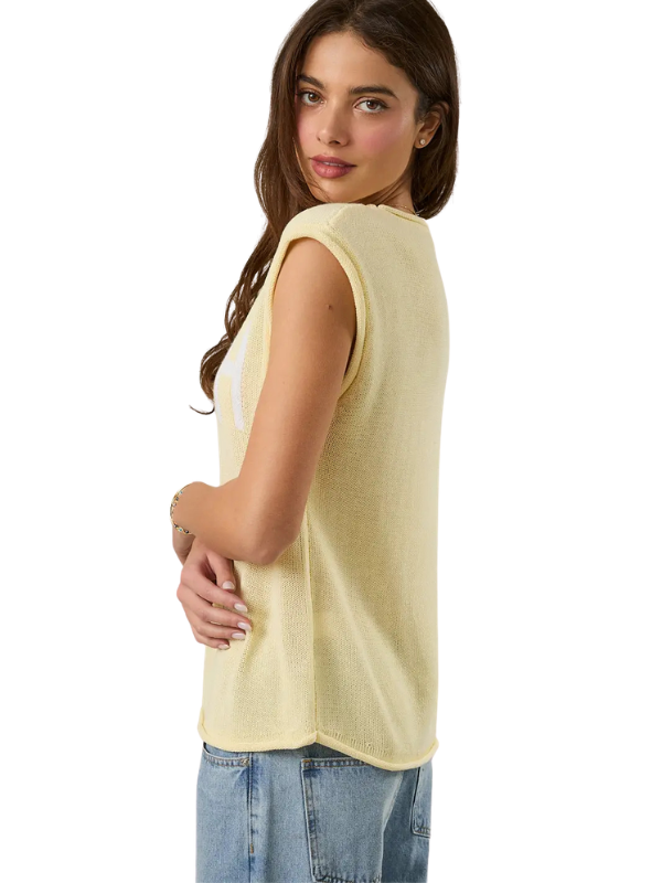Woman wearing a light yellow sleeveless top and blue jeans on a white background