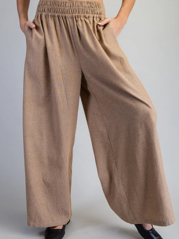 Beige wide-leg pants worn by a person on a plain background