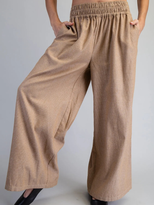 Beige wide-leg pants worn by a person on a plain background