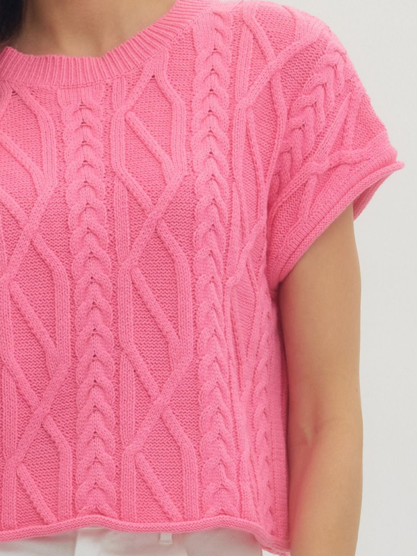 Close-up of a pink knitted sweater with a white background