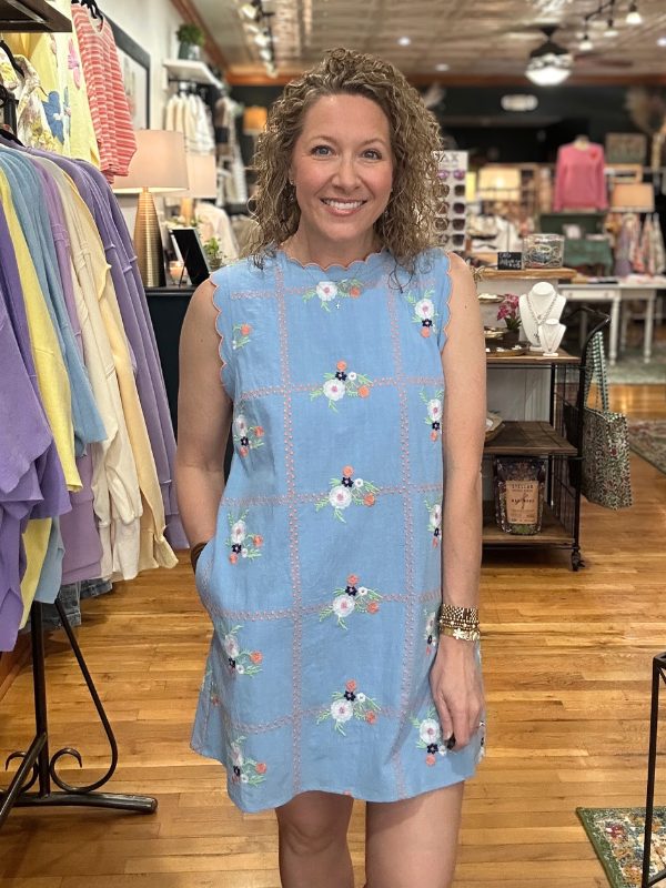 Woman wearing a blue floral dress in a store setting