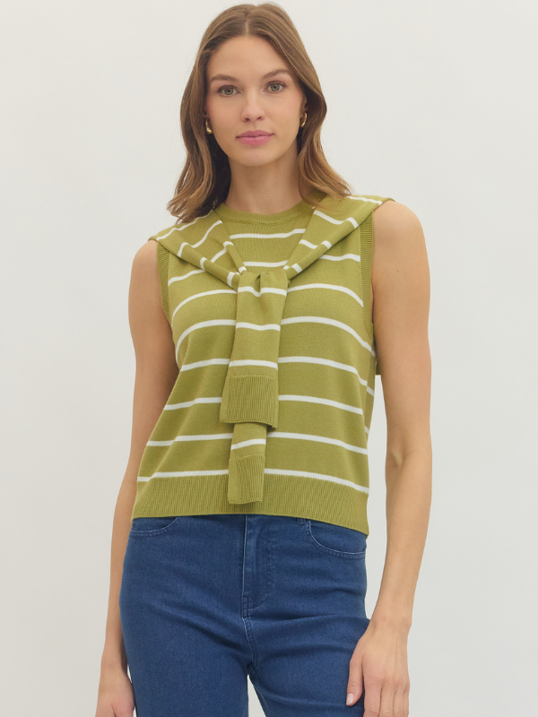 Woman wearing a green and white striped sleeveless top with a bow detail on a plain background