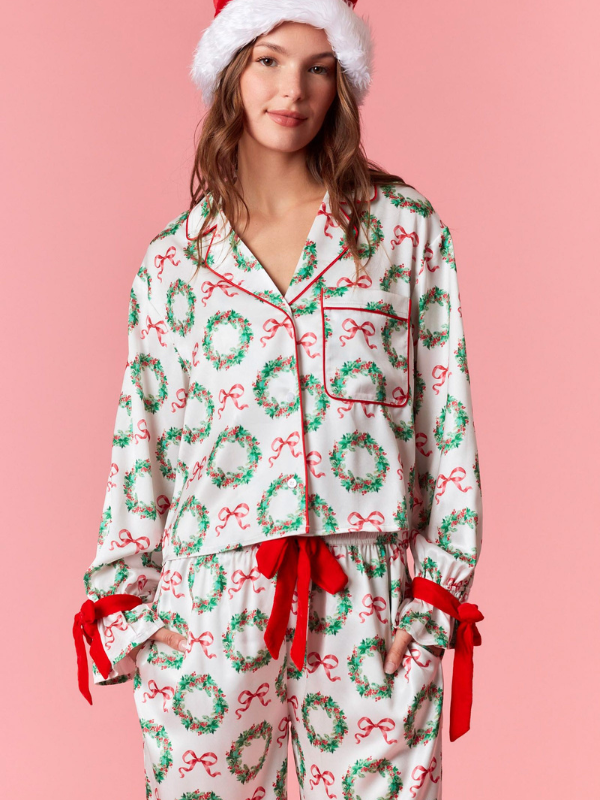 Woman wearing Christmas-themed pajamas with a pink background