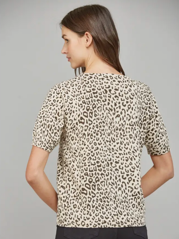 Woman wearing a leopard print top against a gray background