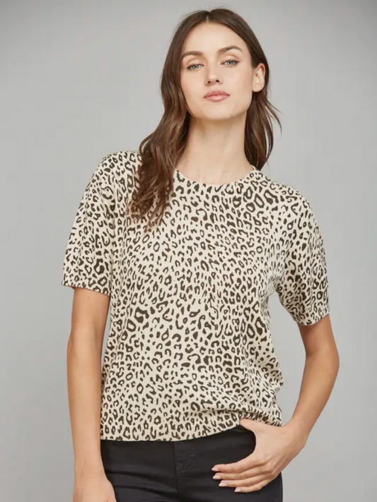 Woman wearing a leopard print top against a gray background