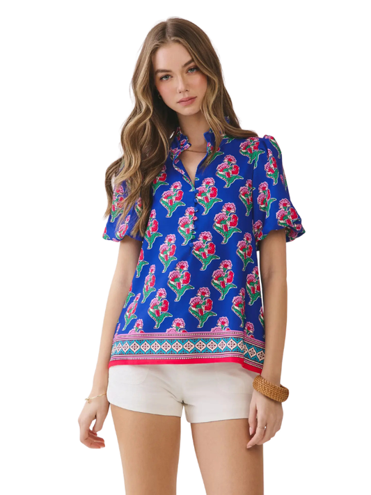 Woman wearing a colorful floral blouse with a white background