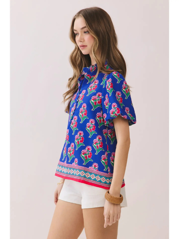 Woman wearing a blue floral blouse with a white background