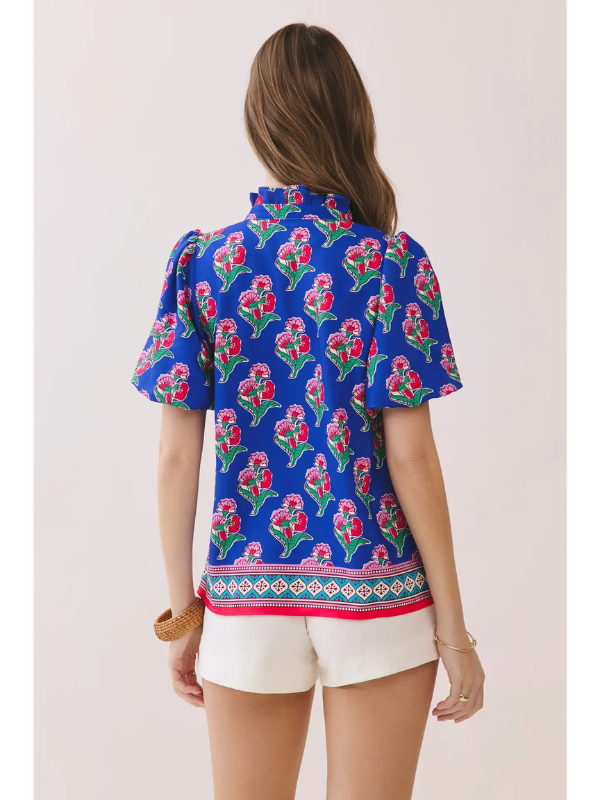 Woman wearing a blue floral blouse with a white background