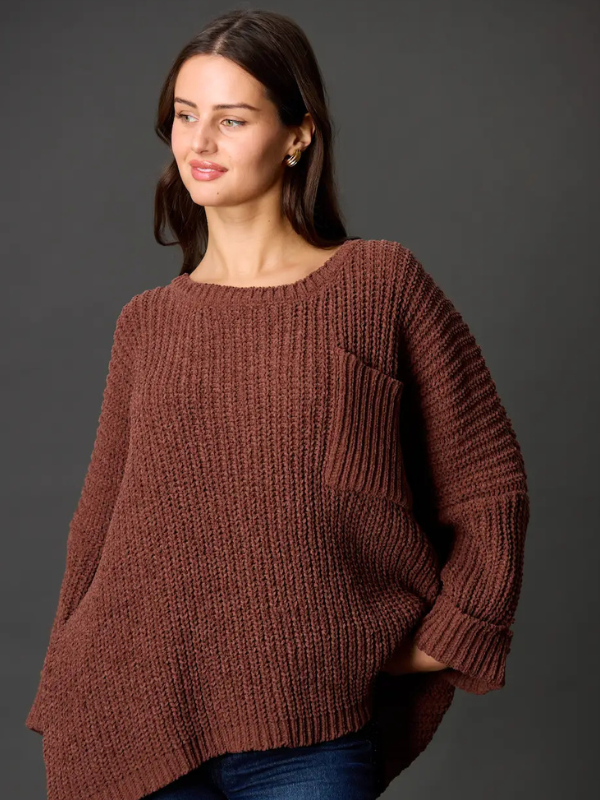 Woman wearing a brown knitted sweater against a gray background