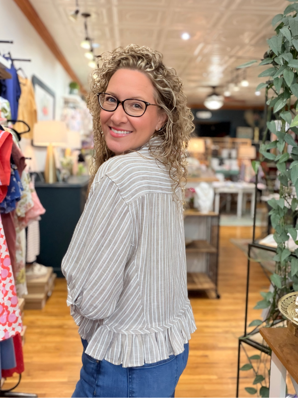 Woman wearing a striped blouse and glasses in a store setting