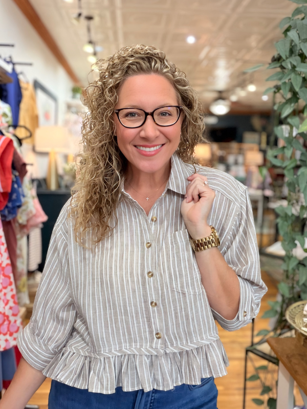 Woman wearing a striped blouse in a store setting