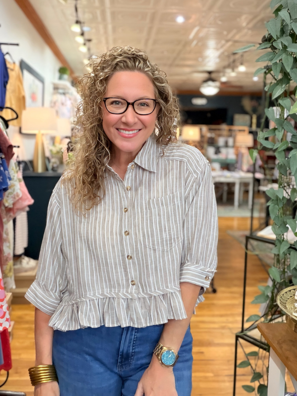 Woman wearing a striped shirt and glasses in a store setting