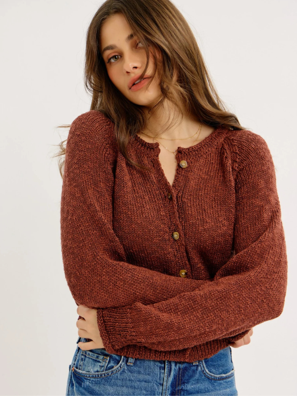 Woman wearing a brown knitted cardigan on a white background