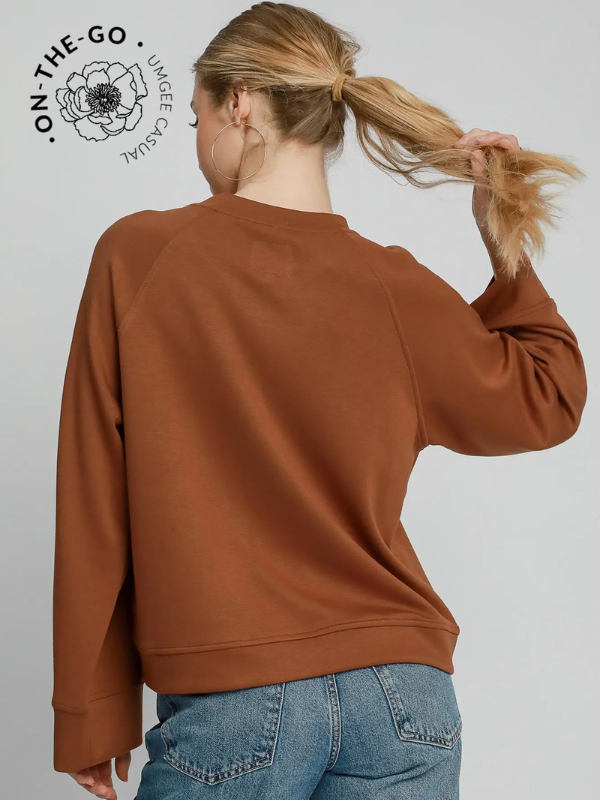 Person wearing a brown sweatshirt and blue jeans with 'On-The-Go' logo in the corner.