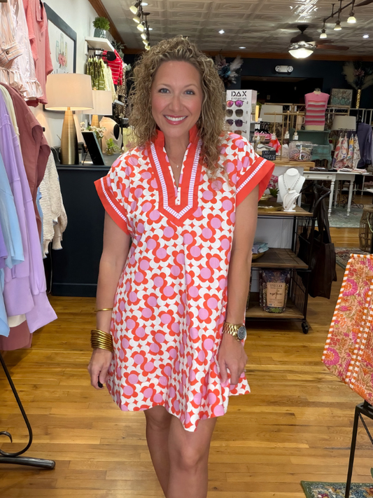 Woman wearing a red and white patterned dress in a store setting
