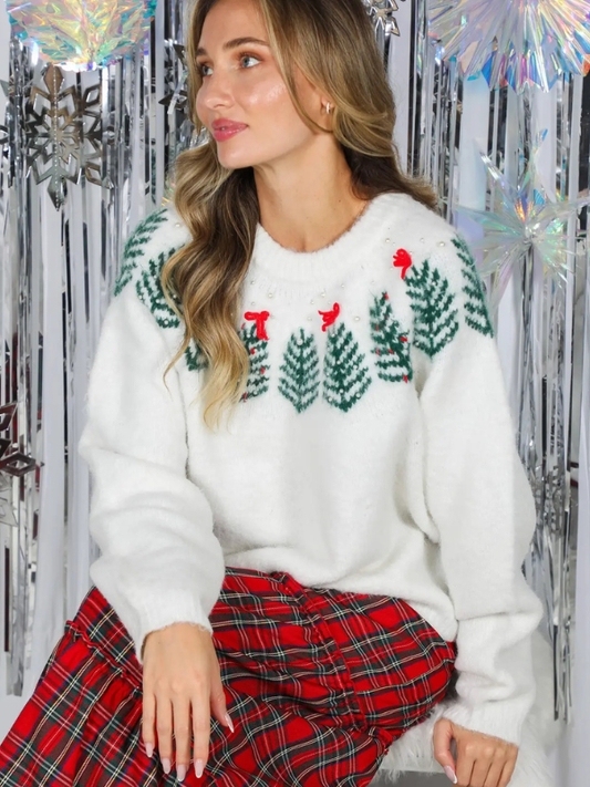 woman wearing a cream Christmas tree sweater 