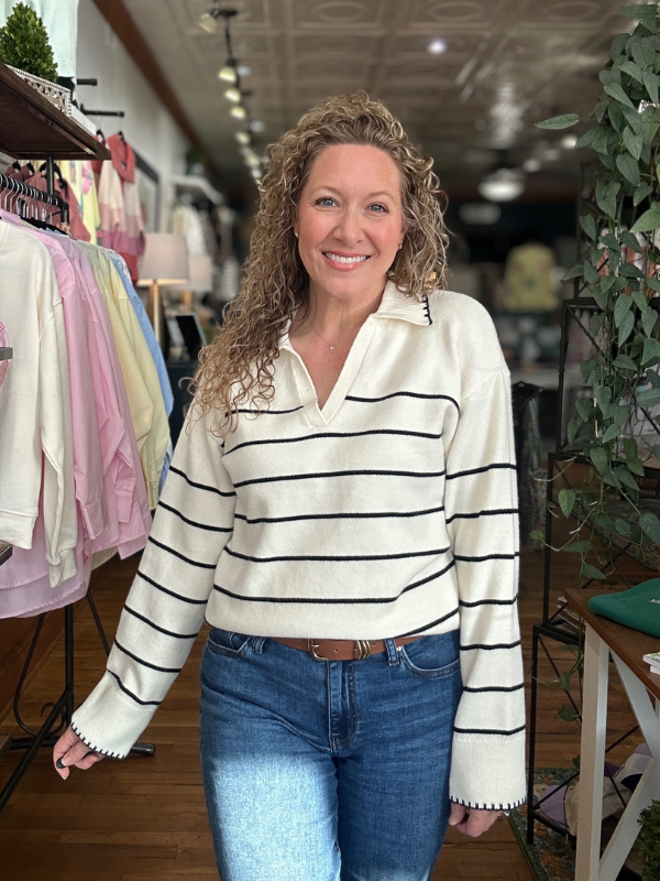 Woman wearing a striped sweater and jeans in a store setting
