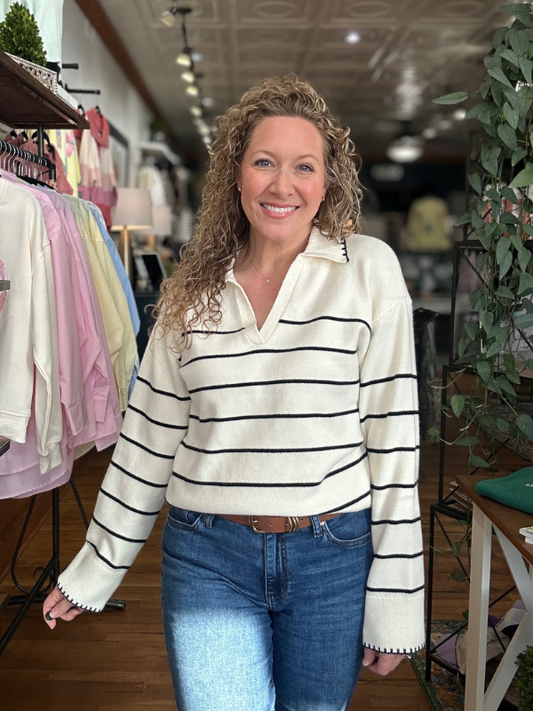Woman wearing a striped sweater and jeans in a store setting