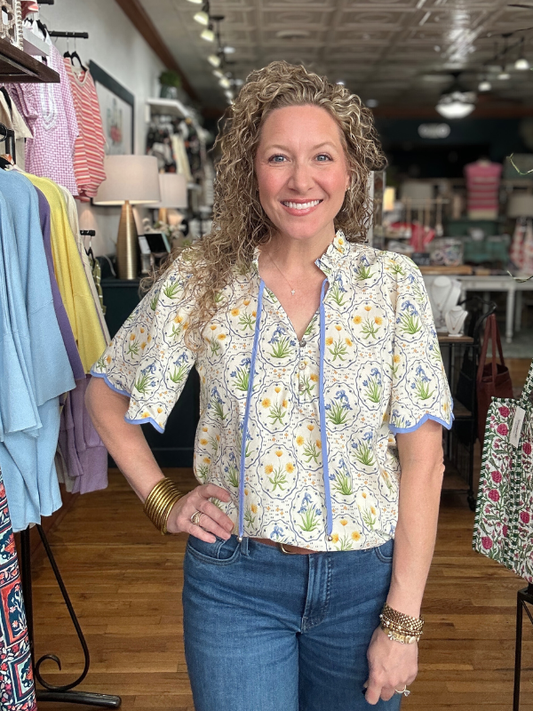 Woman wearing a floral blouse and jeans in a clothing store