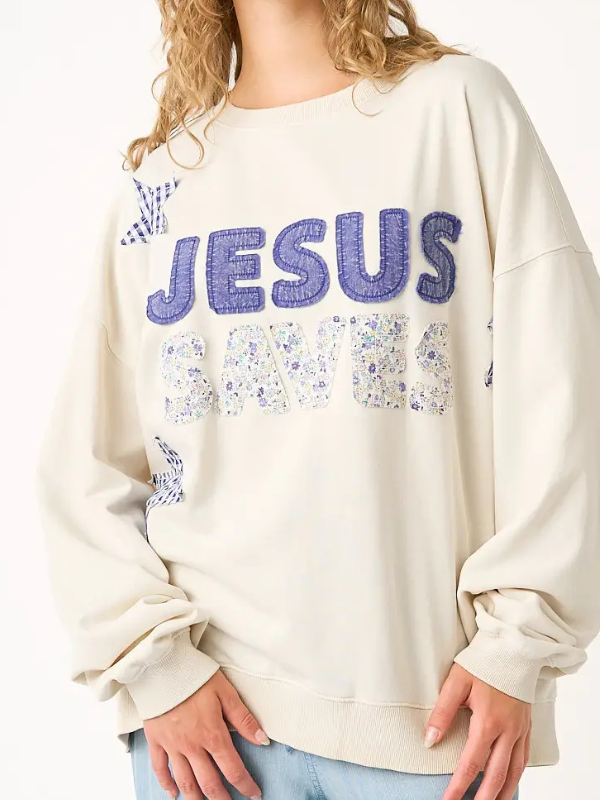 Beige sweatshirt with 'Jesus Loves' text in blue and purple on a plain background
