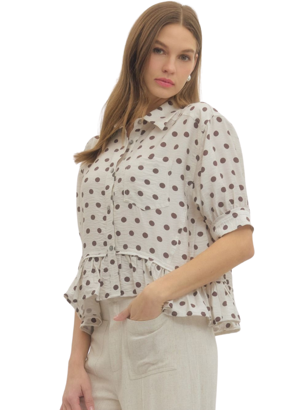 Woman wearing a polka dot blouse with ruffled layers on a white background