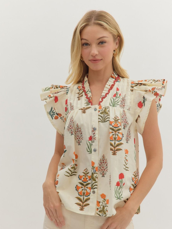Woman wearing a floral blouse against a plain background
