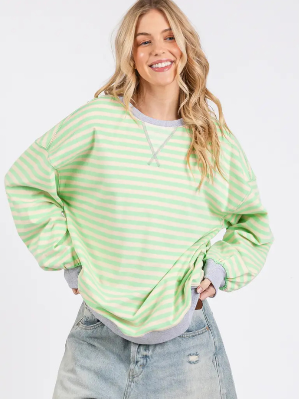 Woman wearing a green and white striped sweater on a white background