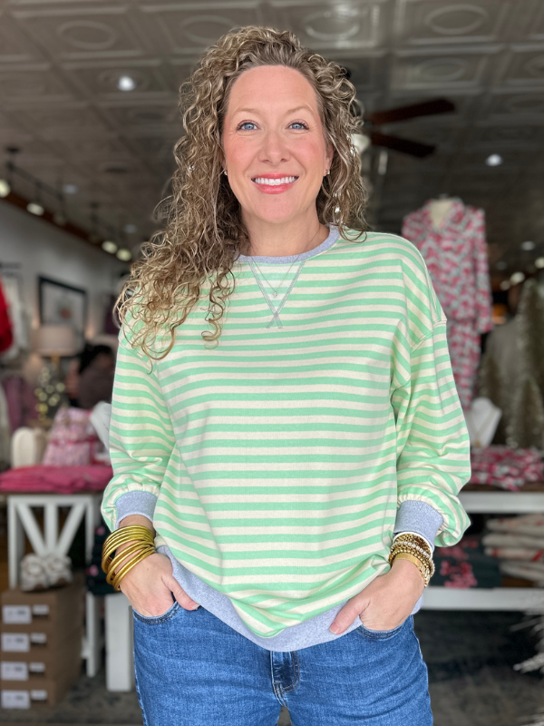 Woman wearing a green and white striped sweater in a store setting