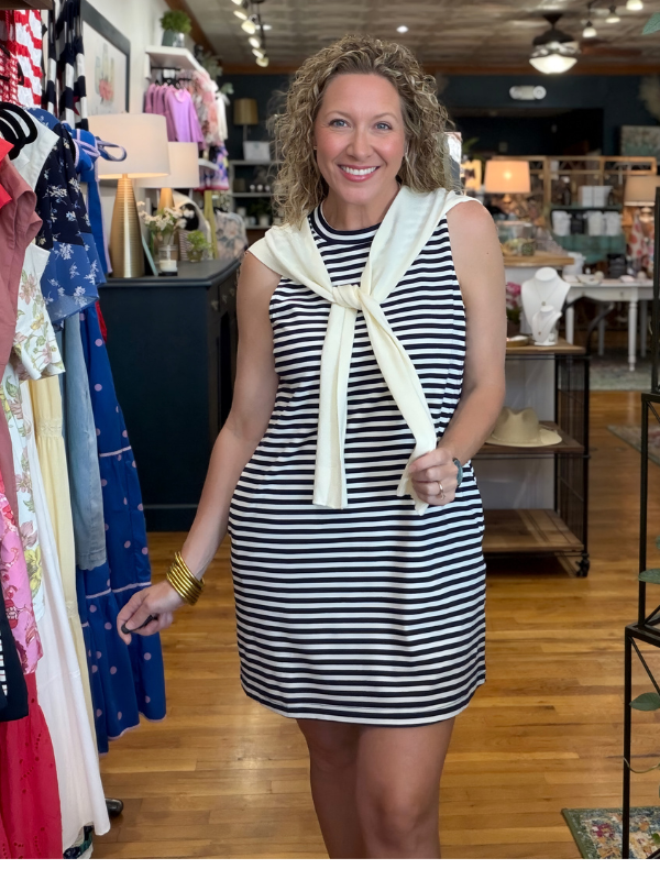 Woman wearing a striped dress with a scarf in a store setting