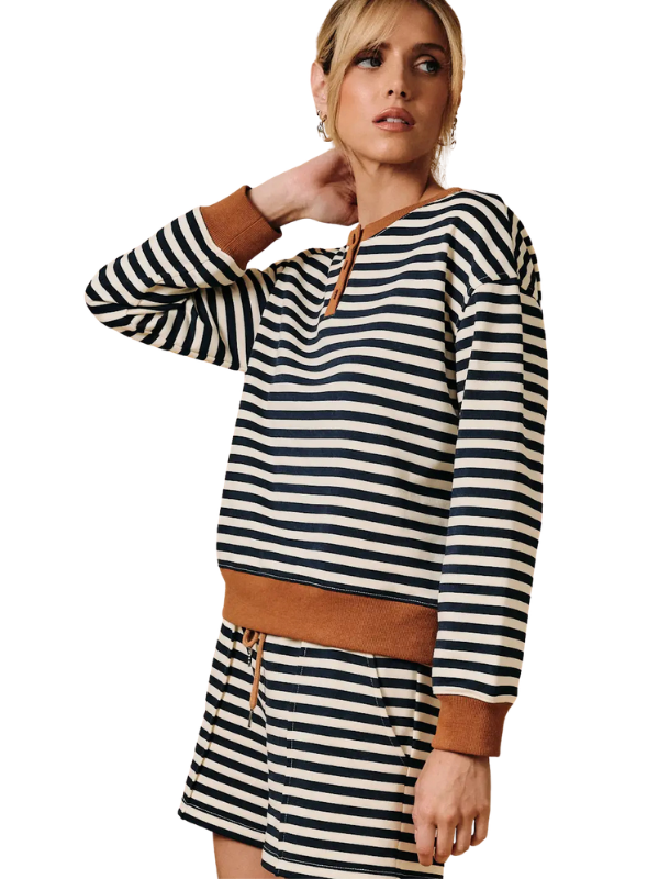 A woman modeling a matching two-piece loungewear set featuring a long-sleeve top and shorts in a black and white horizontal stripe pattern with contrasting brown cuffs, hem, and waistband.