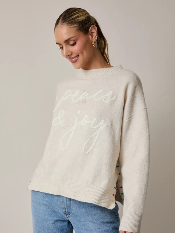 woman wearing a Cream Peace + Joy Sweater