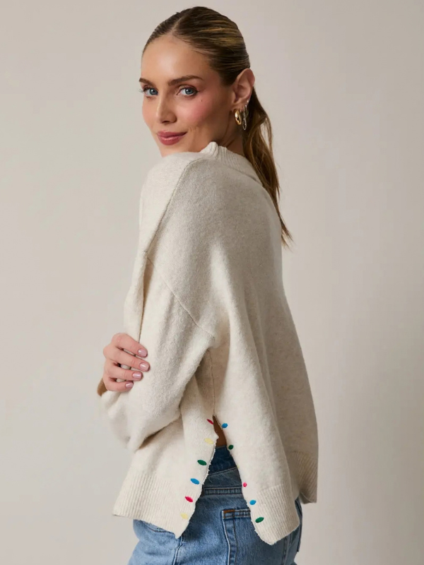 woman wearing a Cream Peace + Joy Sweater