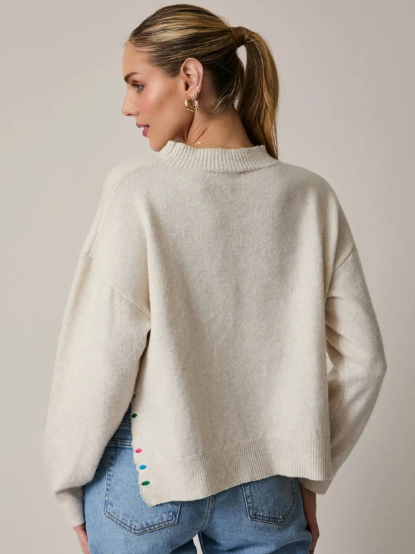 woman wearing a Cream Peace + Joy Sweater