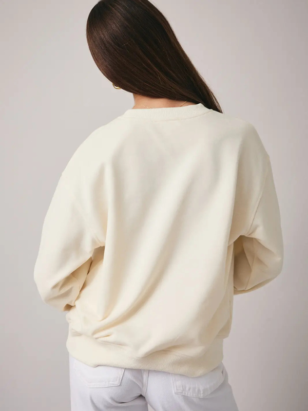 Person wearing a cream-colored sweater against a plain background