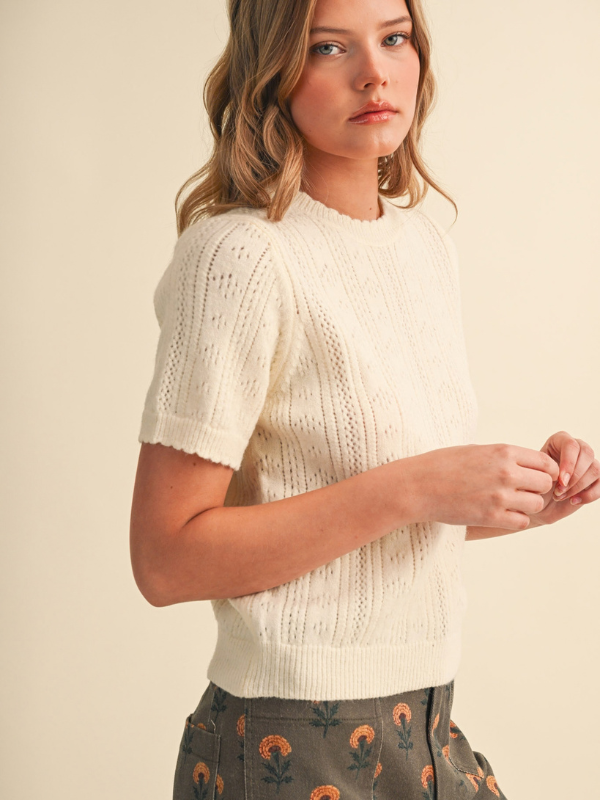 woman wearing a cream pointelle sweater 