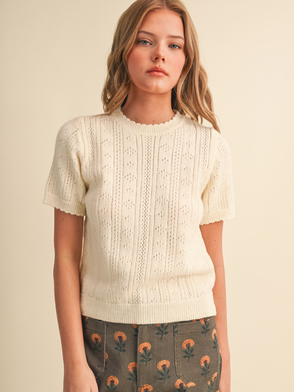 woman wearing a cream pointelle sweater 