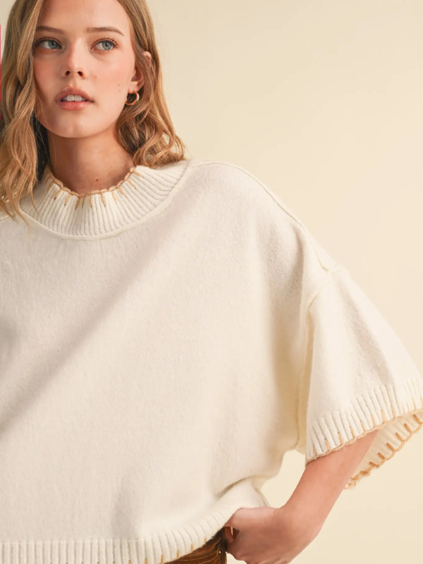 woman wearing a cream blanket stitched sweater 