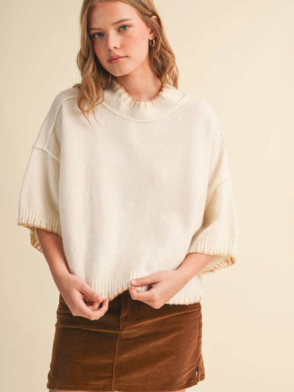 woman wearing a cream blanket stitched sweater 