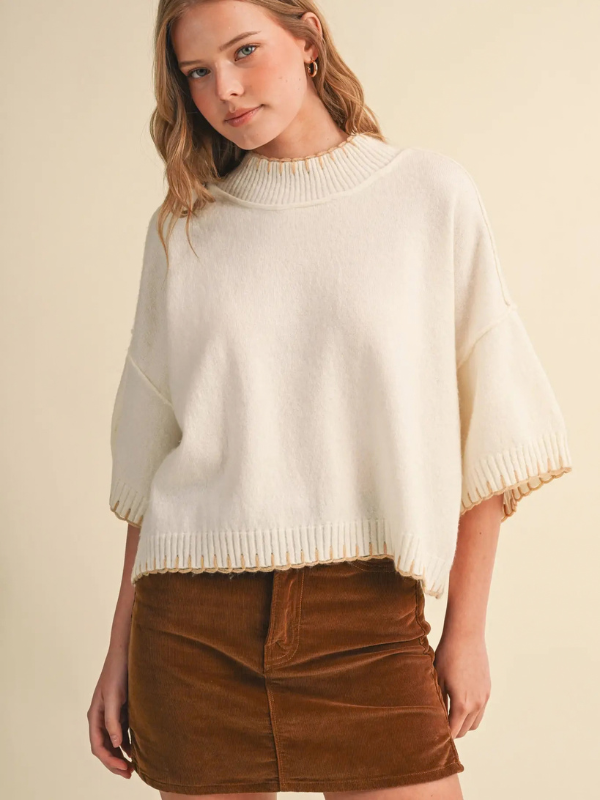 woman wearing a cream blanket stitched sweater 