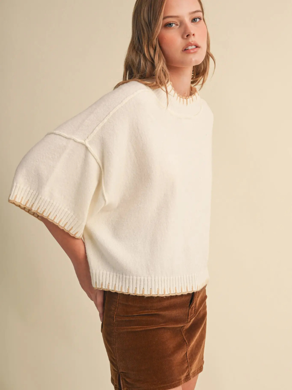 woman wearing a cream blanket stitched sweater 