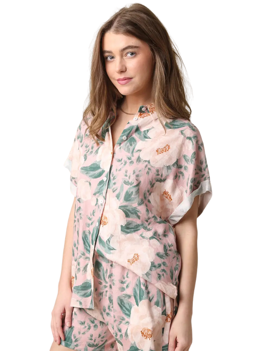 Woman wearing a floral pajama set on a white background